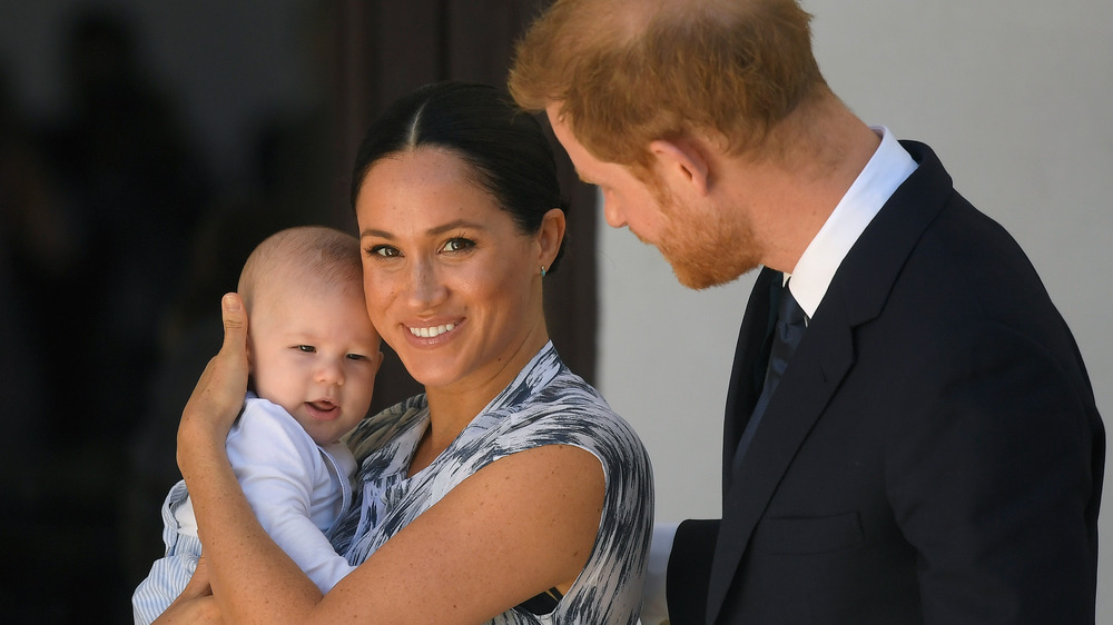 Meghan Markle holding son Archie while standing with Prince Harry