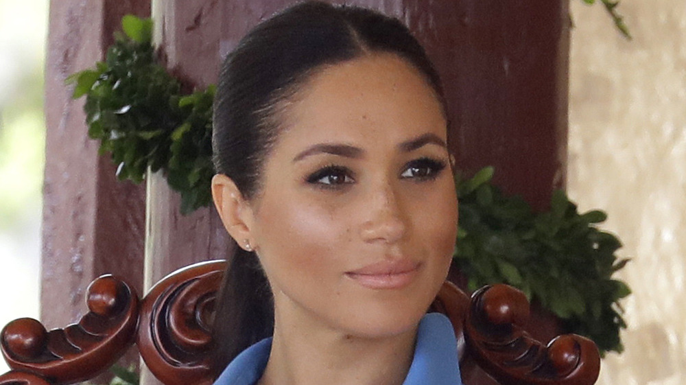 Meghan Markle wearing a ponytail and blue dress