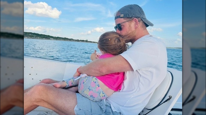 Prince Harry holding Princess Lilibet on a boat