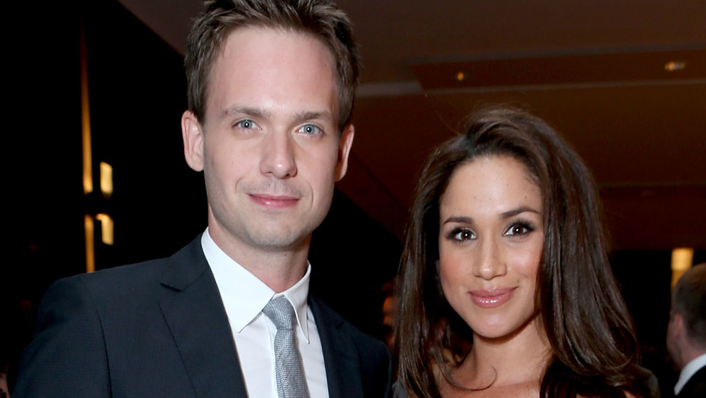 Patrick J. Adams poses with Meghan Markle at an event