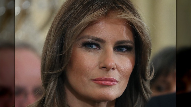 Melania Trump with a serious look and pink lipstick