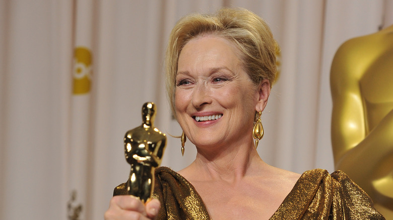 Meryl Streep smiling and holding an Academy Award
