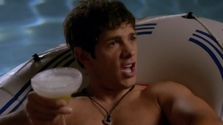 Michael Rady holding a drink on a pool float