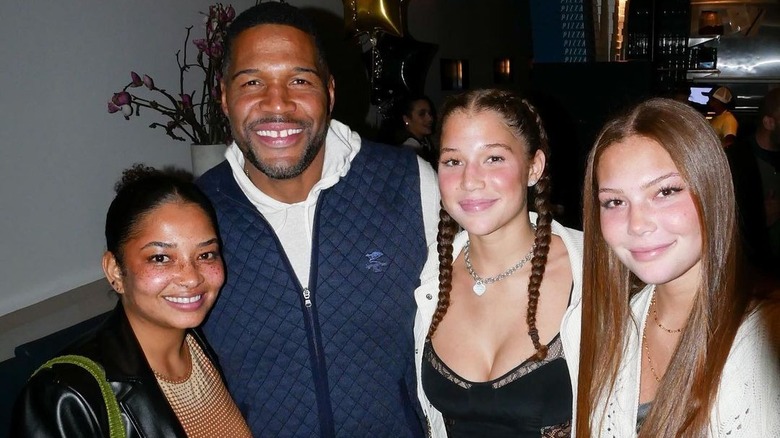 Micheal Strahan posing with his daughters