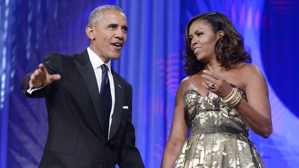 Barack and Michelle Obama hold hands