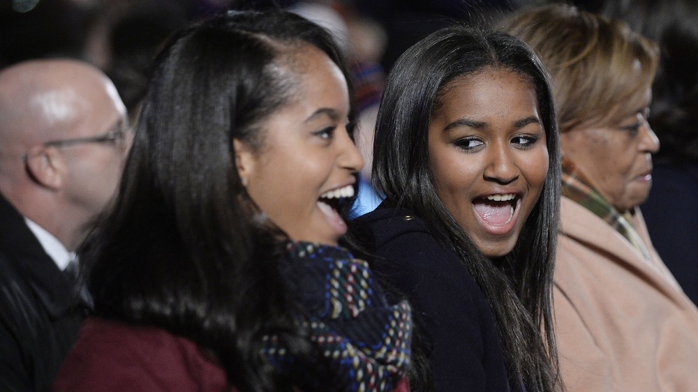 Malia and Sasha Obama smiling at an event