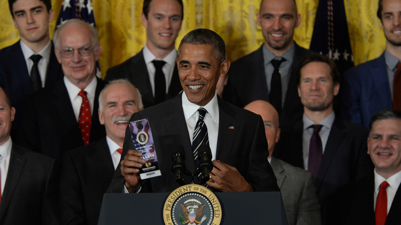 Barack Obama holding up a parking pass