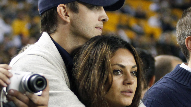 Ashton Kutcher holding Mila Kunis