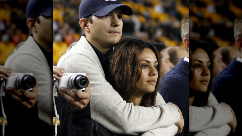 Ashton Kutcher with his arms around Mila Kunis