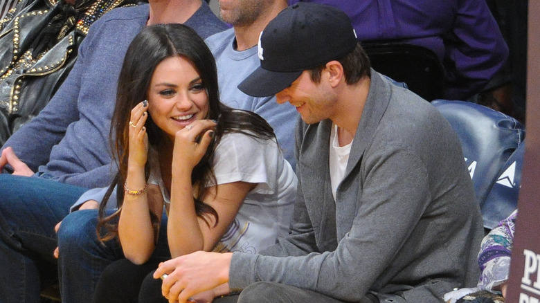 Mila Kunis and Ashton Kutcher at a basketball game