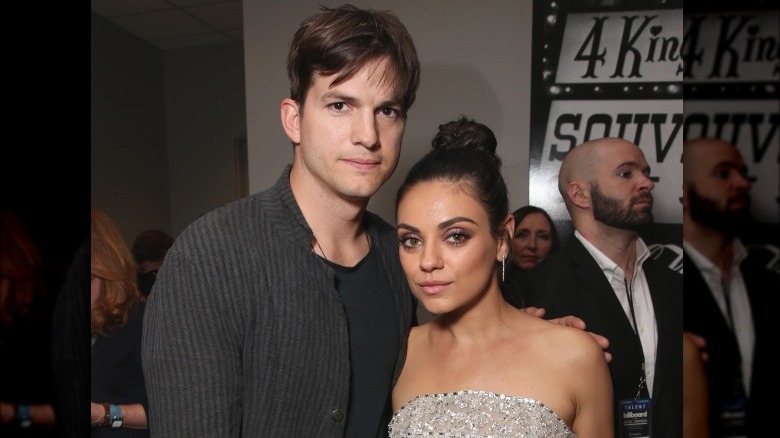 Ashton Kutcher and Mila Kunis posing for a photo at an event