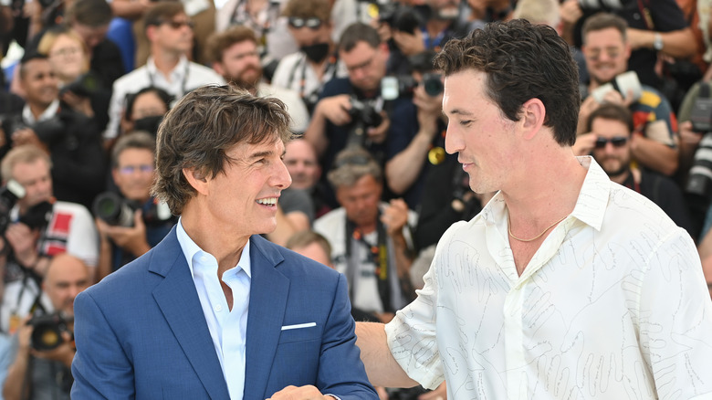 Tom Cruise and Miles Teller smiling