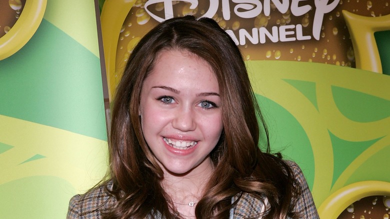 A young Miley Cyrus smiling