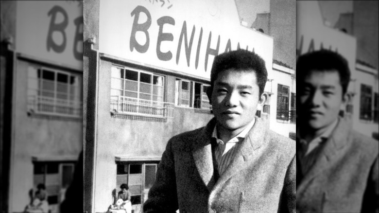 Rocky Aoki poses in front of the first Benihana