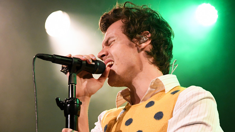 Harry Styles signing in yellow vest