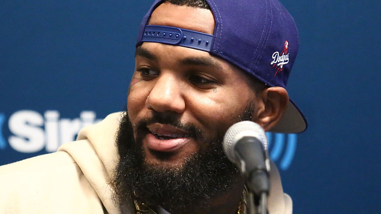 The Game wearing a blue cap