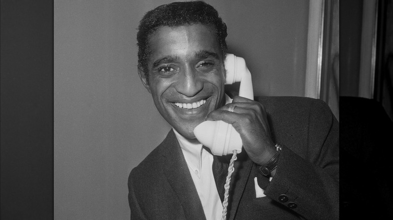 Sammy Davis Jr. smiling on the phone