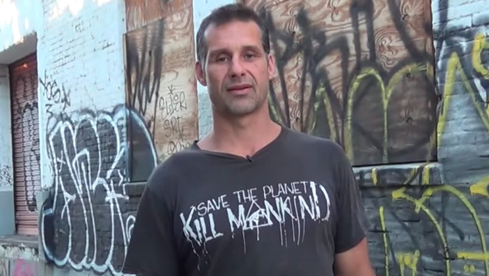 Gary Golding wearing a Save The Planet Kill Mankind shirt 