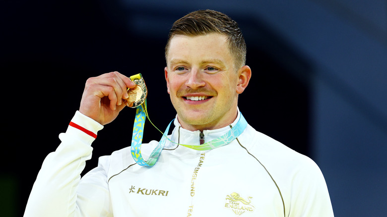 Adam Peaty holding medal