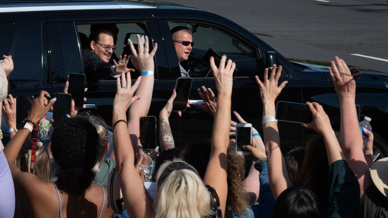 A crowd takes photos of Johnny Depp with their phones