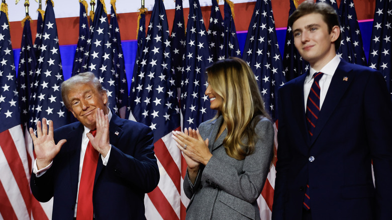 Barron Trump and Melania Trump celebrate Donald Trump's victory in front of American flags