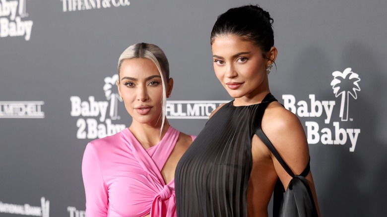 Kim Kardashian in pink dress and Kylie Jenner in black dress