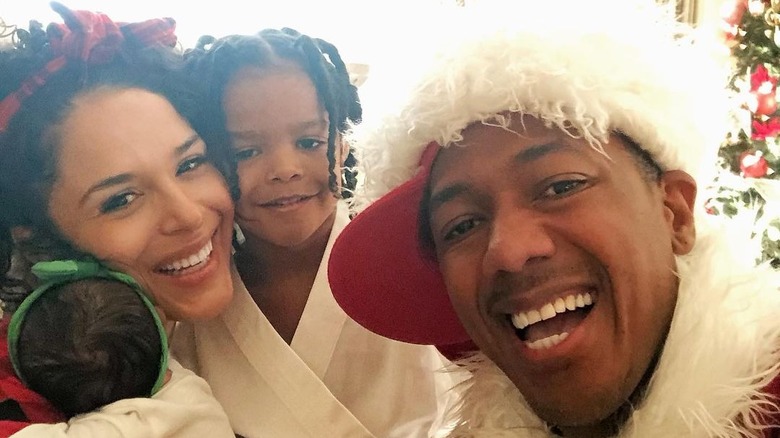 Brittany Bell and Nick Cannon smiling with their kids