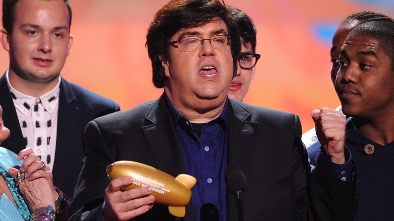 Dan Schneider speaking and holding an award