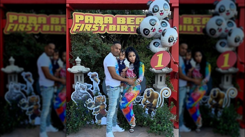 Nicki Minaj and Kenneth Petty hold baby Papa Bear under a birthday banner