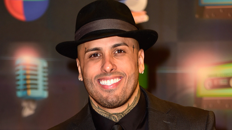 Nicky Jam smiling in hat