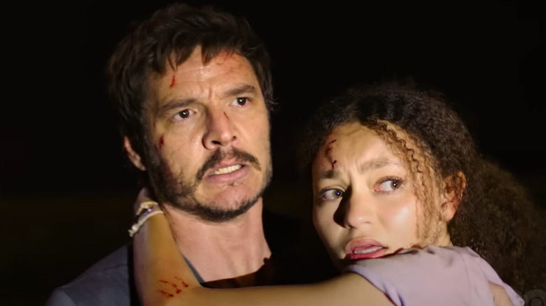 Nico Parker with arm around Pedro Pascal's neck