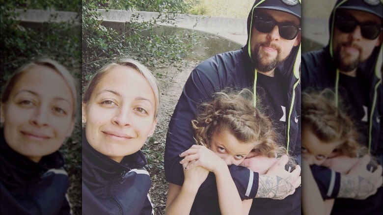 Nicole Richie and Joel Madden posing with their daughter