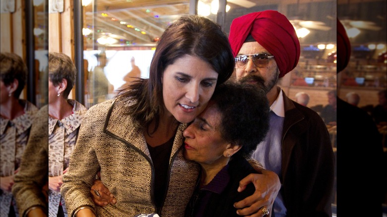 Nikki Haley hugging her mom, her dad standing behind them