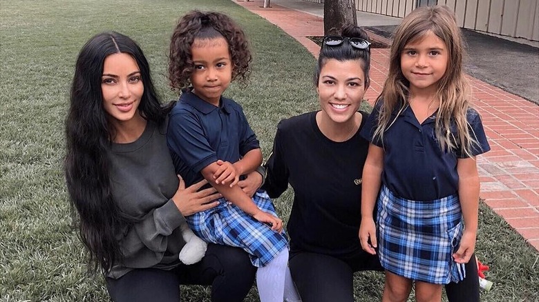 North West and Penelope Disick smiling at school by their moms.