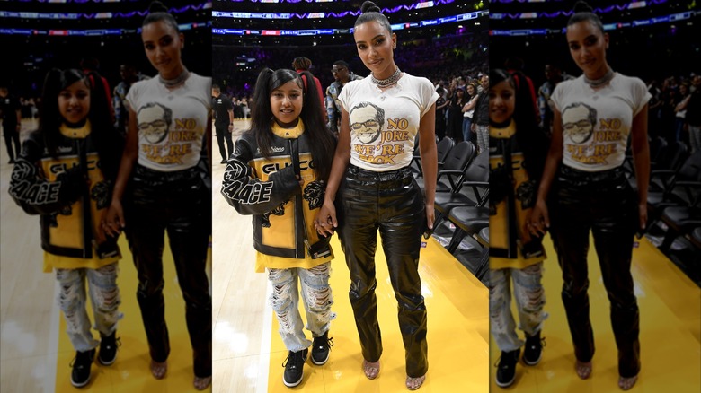 North West and Kim Kardashian posing at a basketball game