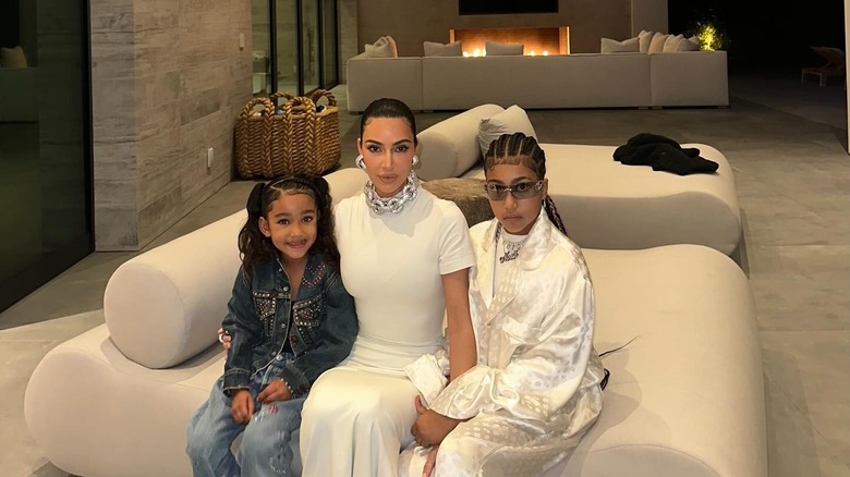 North West sitting on the couch with Kim Kardashian and Chicago West.