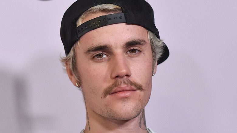 Justin Bieber with mustache and hat