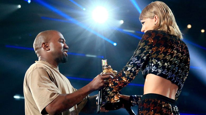 Taylor Swift presents Kanye West with his award at the 2015 VMAs