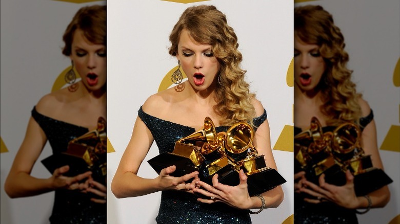 Taylor Swift posing with Grammy awards in the press room during the 52nd Annual GRAMMY Awards