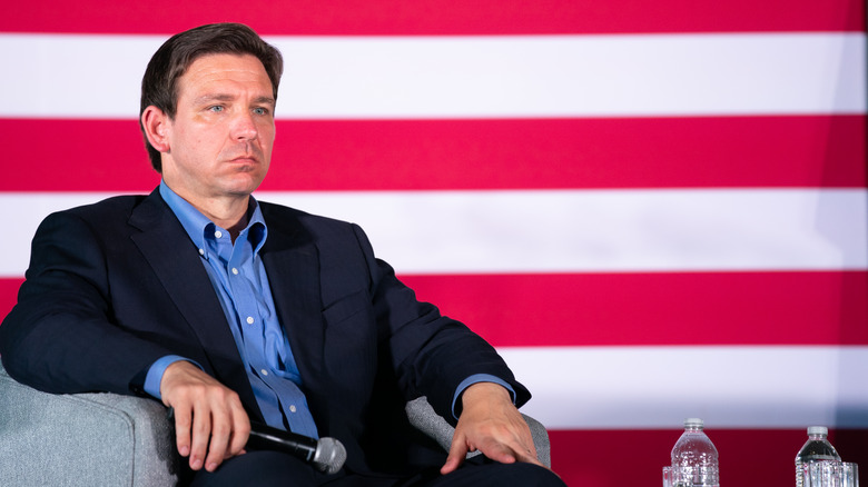 Ron DeSantis sitting in front of U.S. flag