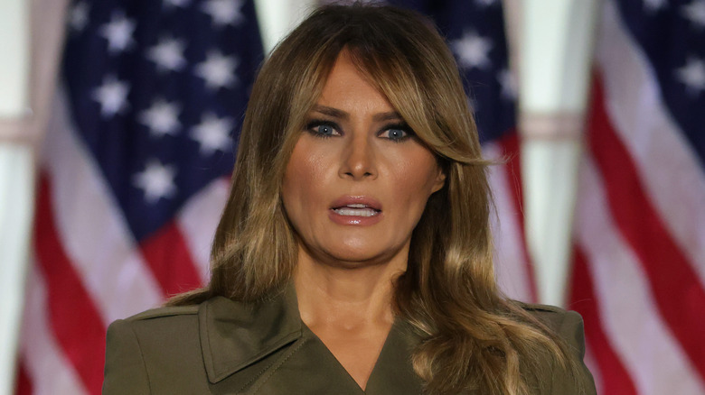 Melania Trump speaking in front of American flags