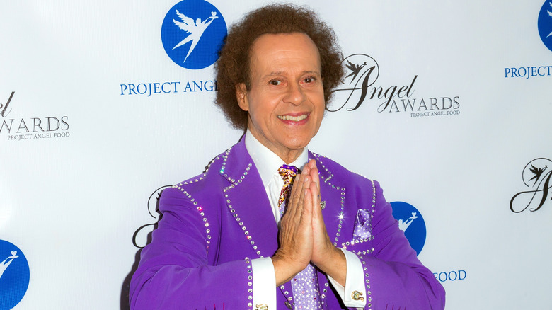 Richard Simmons with palms pressed together