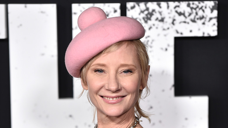 Anne Heche smiling wearing pink bobble hat