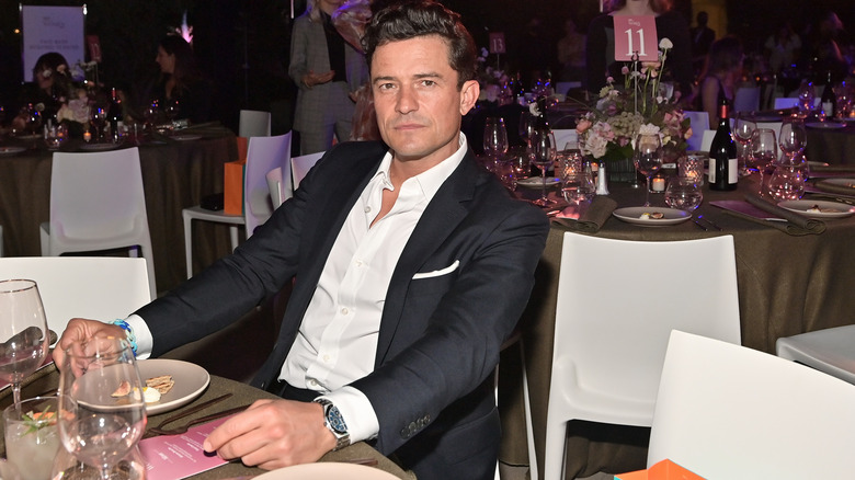 Orlando Bloom sitting at a table