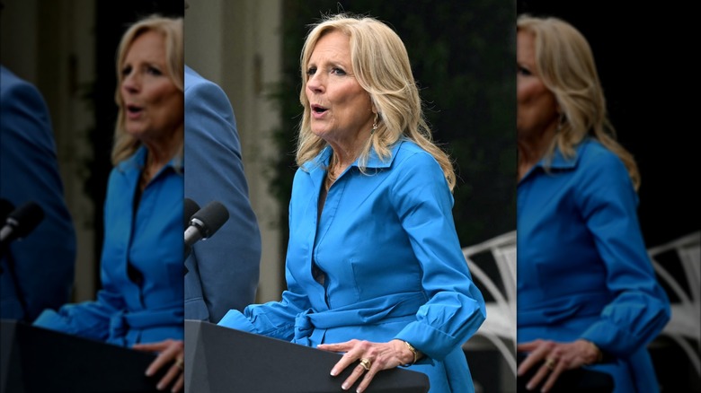 Jill Biden wearing blue dress and talking into microphone