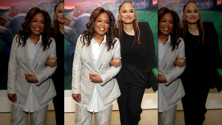 Oprah Winfrey wearing gray suit and linking arms with Ava DuVernay at the after party for "Exhibiting Forgiveness"