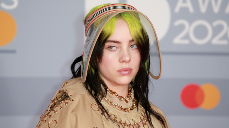 Billie Eilish wearing transparent visor with green and black hair