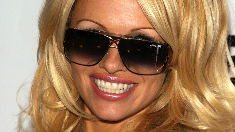 Pamela Anderson smiling in sunglasses