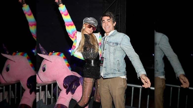 Paris Hilton and Brent Bolthouse posing together at Neon Carnival