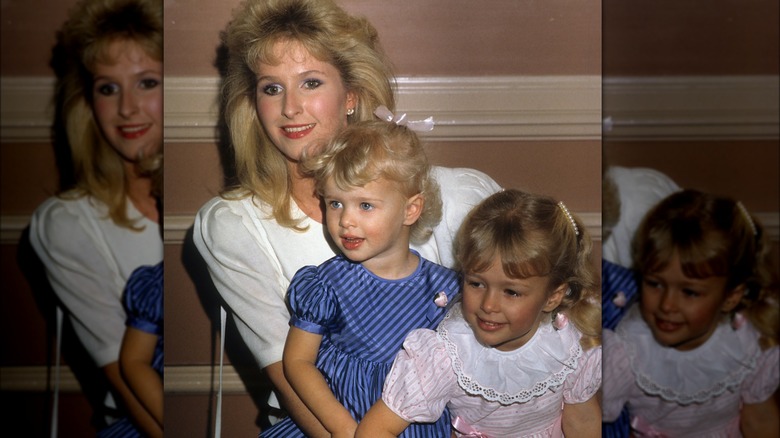 Young Paris Hilton sitting with mom Kathy and sister Nicky